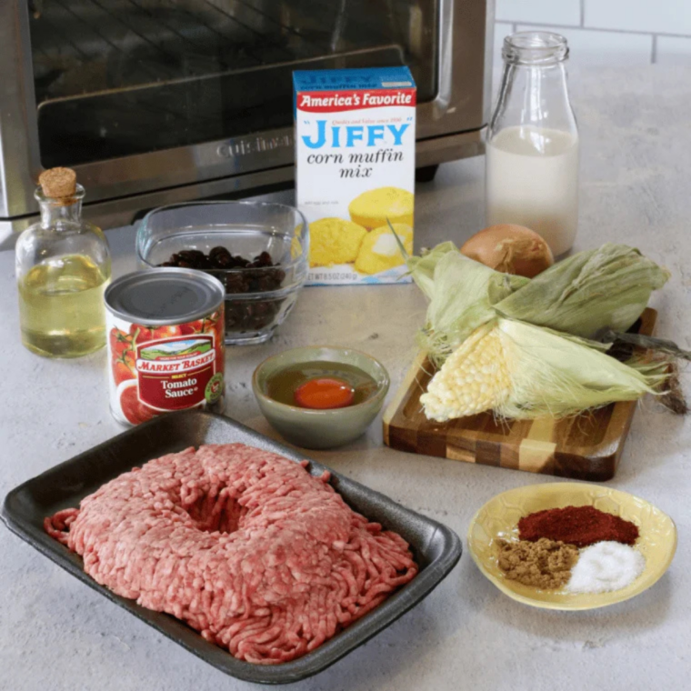 Ingredients for air fryer chili with cornbread topping, including ground beef, black beans, corn, tomato sauce, and Jiffy corn muffin mix