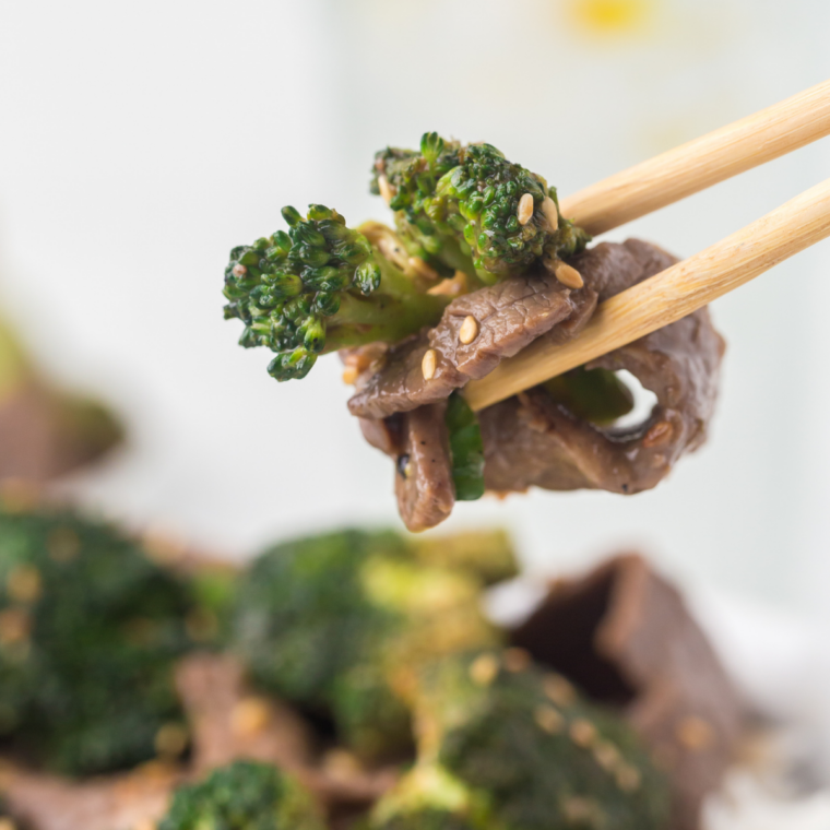 Blackstone broccoli sizzling on a flat top griddle, bright green and lightly charred
