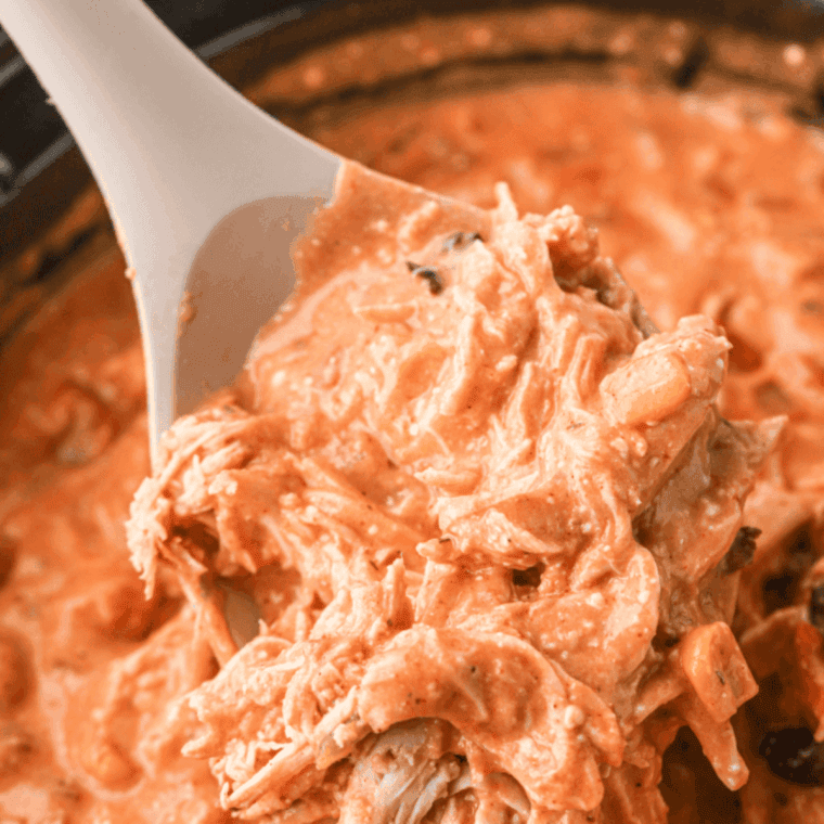 Bowl of Copycat Crockpot Jason’s Deli Chicken Chili topped with shredded cheese, sour cream, tortilla strips, and fresh cilantro.