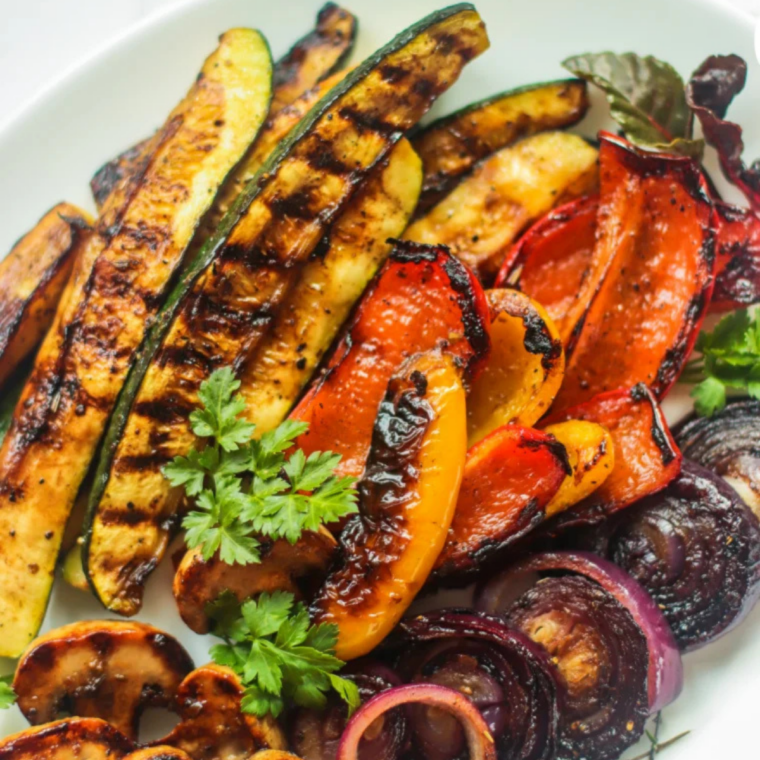 Colorful balsamic-glazed vegetables sizzling on a Blackstone griddle.