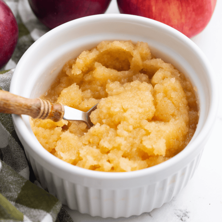 Easy air fryer applesauce in a white bowl topped with a sprinkle of ground cinnamon