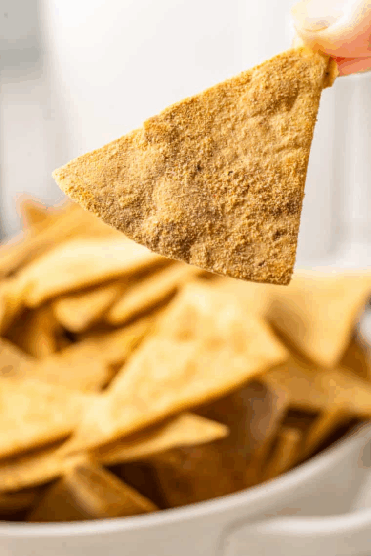 Evenly coat tortilla triangles with seasoning mixture for flavor.