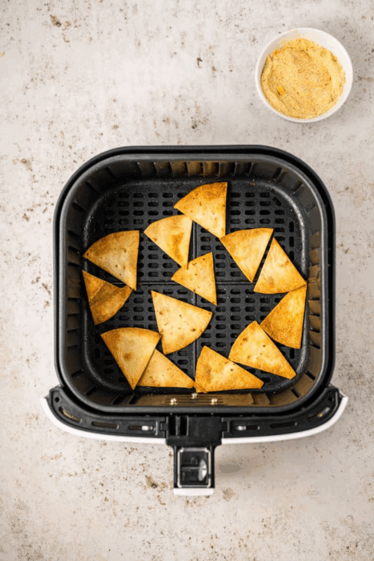 Evenly coat tortilla triangles with seasoning mixture for flavor.