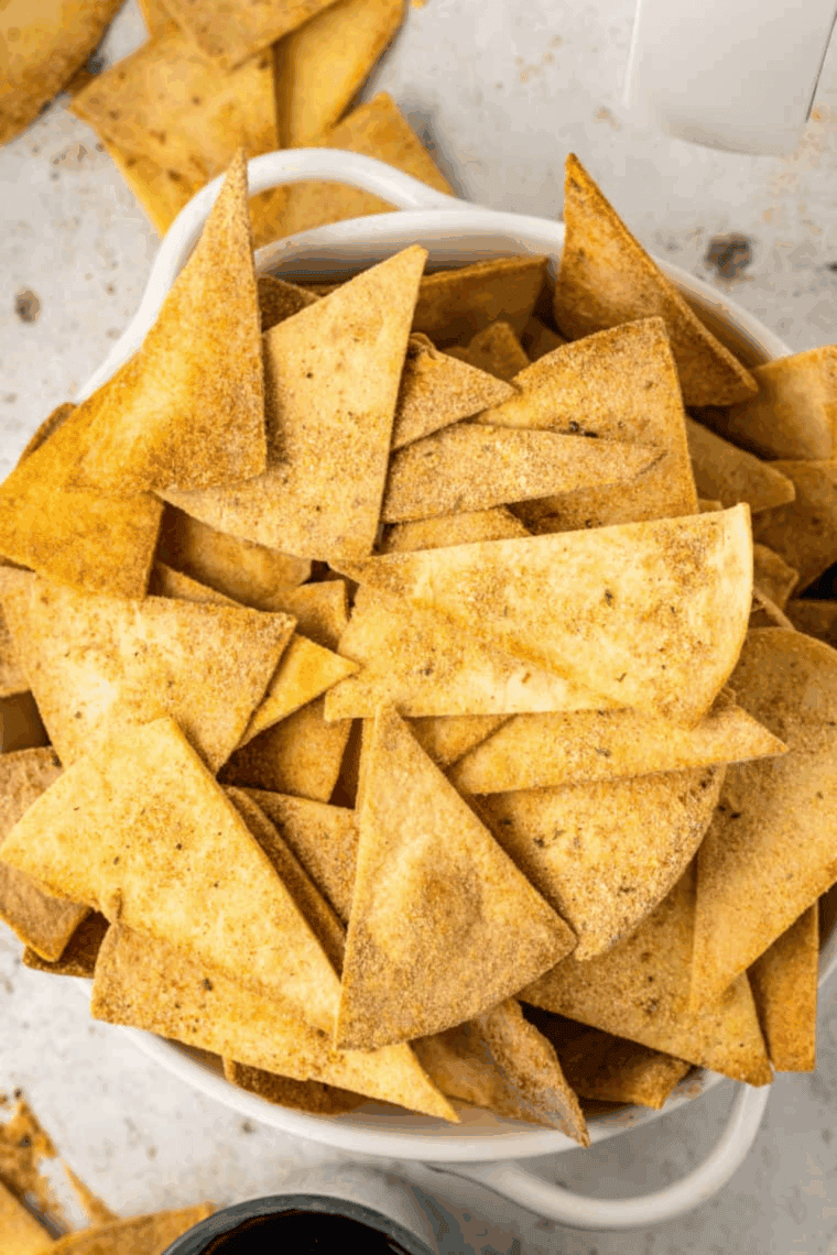 Plate of homemade Air Fryer Cool Ranch Doritos, golden and crispy, with a sprinkle of seasoning.