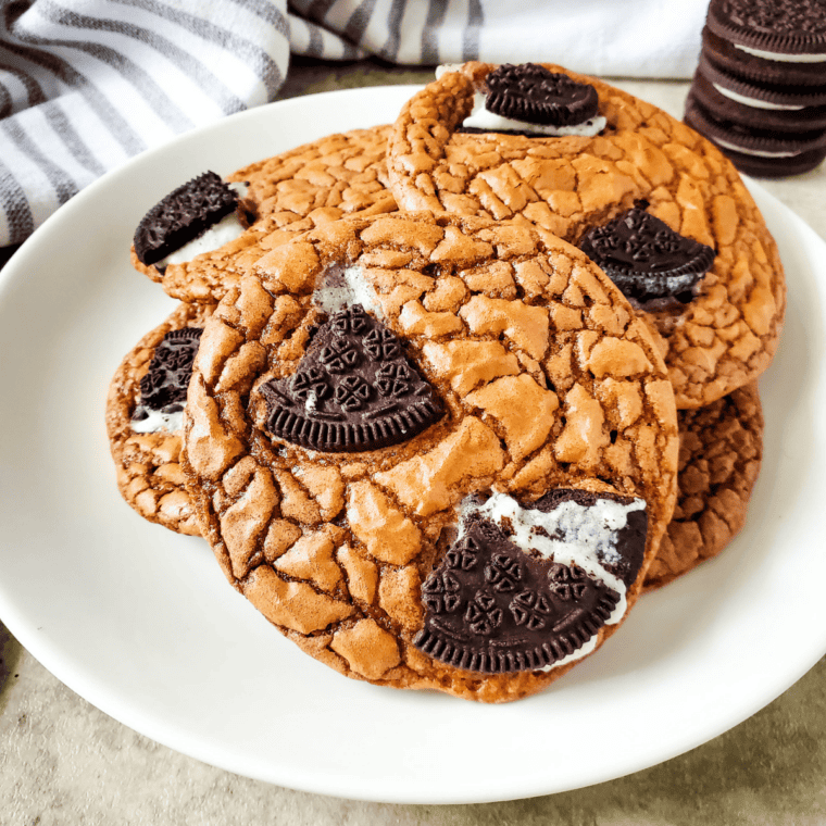 Stack of fudgy Oreo brownie cookies topped with chunks of Oreo on a wire cooling rack