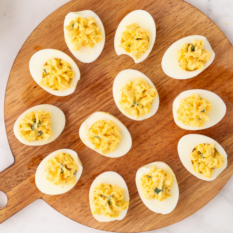 Gluten free deviled eggs on a white platter dusted with paprika