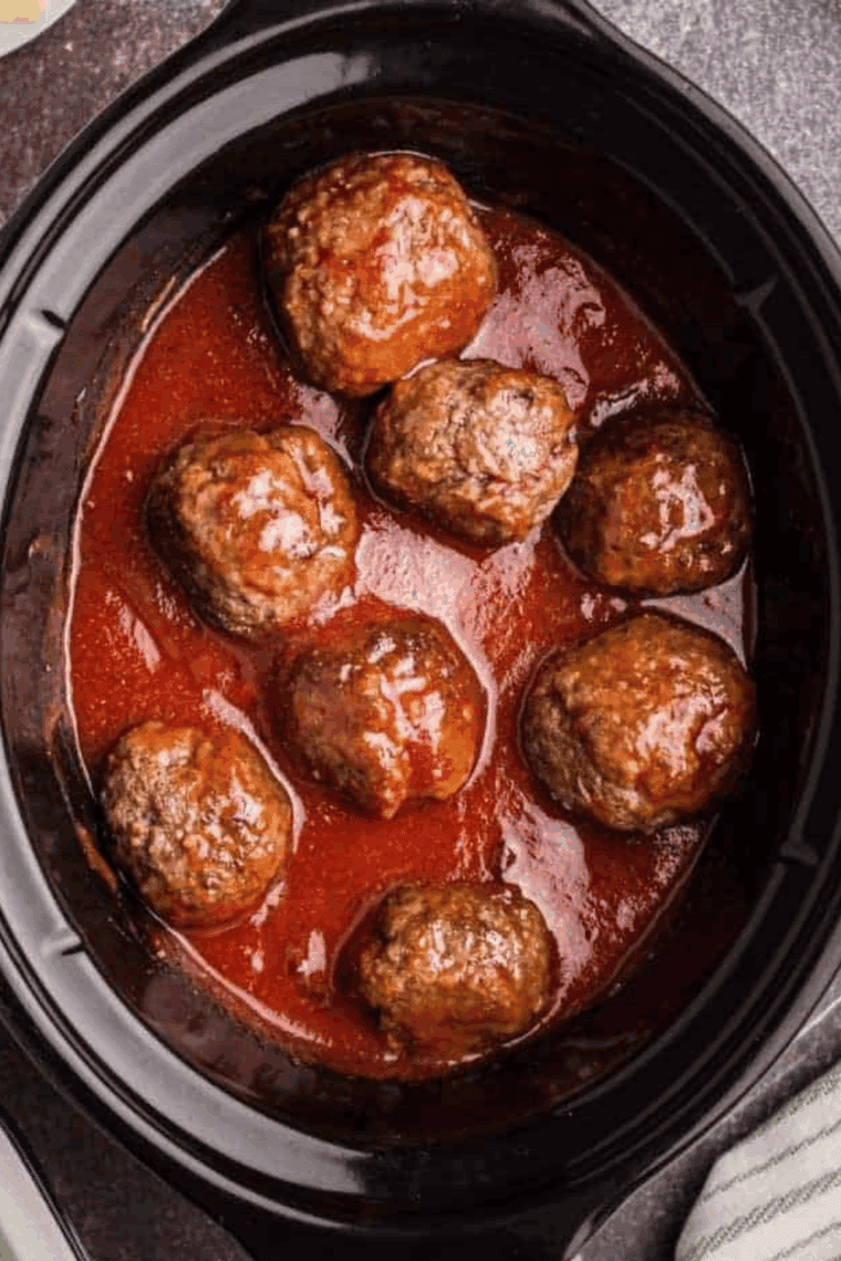 Crock pot filled with tender, cooked frozen meatballs in savory sauce