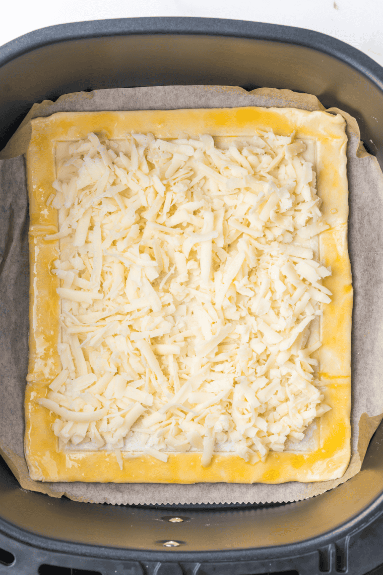 Puff pastry topped with cheese, sautéed onions, and asparagus spears.