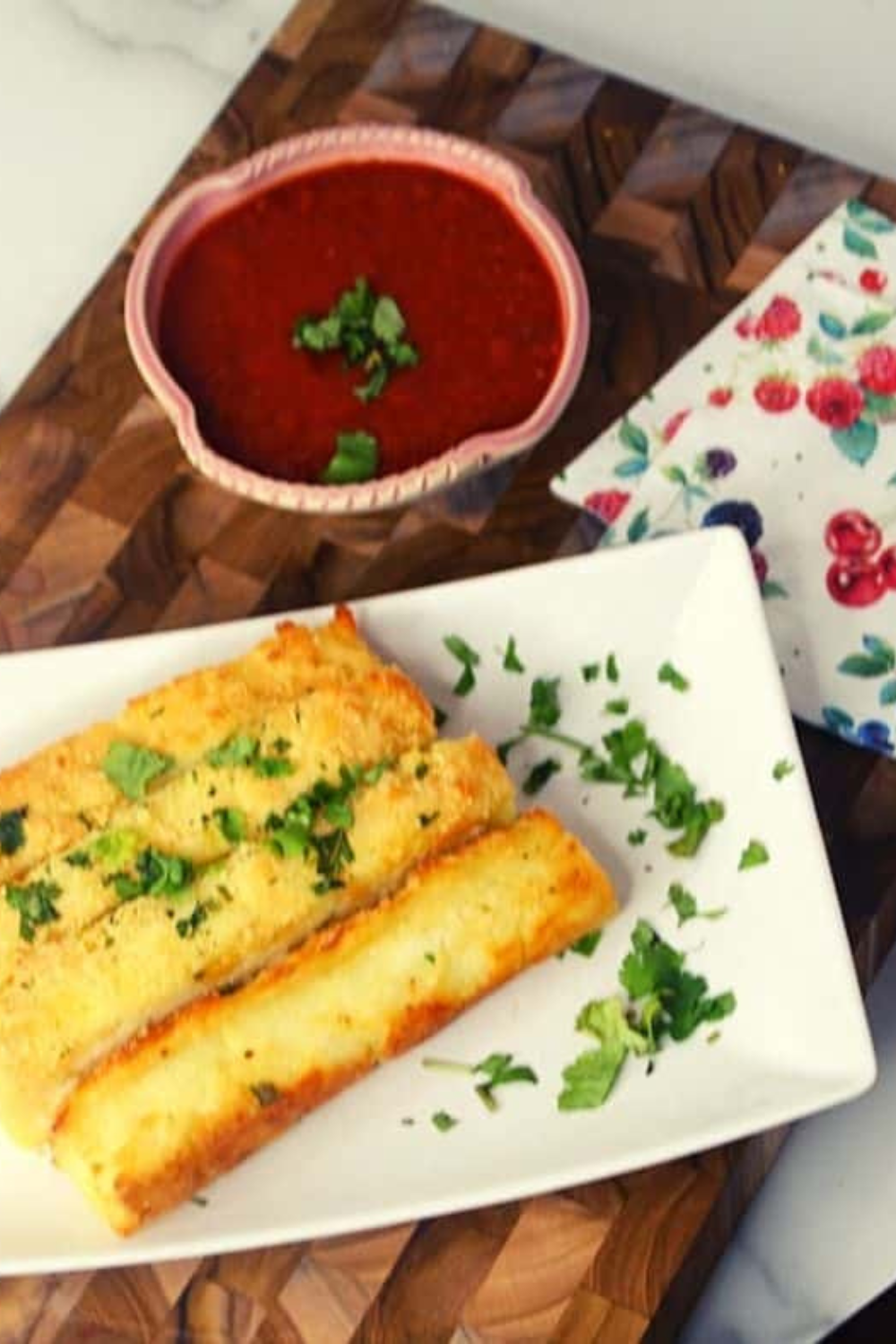 Golden breadsticks sprinkled with Parmesan and garnished with chopped parsley