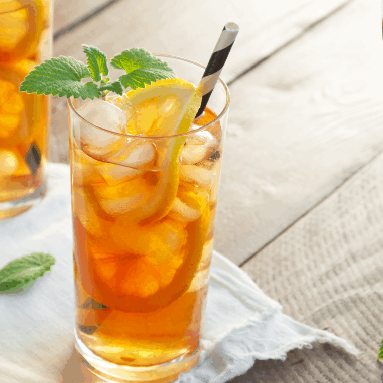 Glass of homemade McDonald’s Sweet Tea copycat recipe with ice and lemon wedge.