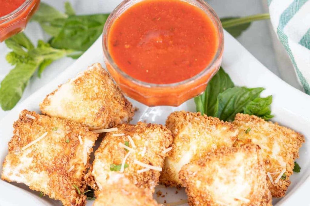 Can I Make Air Fryer Frozen Toasted Ravioli In The Oven? Yes, prepare them, and then instead of putting them into the air fryer, place them into a preheated 400 degrees F for 12-15 minutes. Making them in the oven is an excellent idea if you make a massive batch of them for a party or get-together. Can I Make Use Fresh Ravioli? Yes, change the air frying time to about 3-5 minutes, as they will cook faster than the frozen ones. Next time you are at the store, look around in both the freezer section and the grocery store’s refrigerator section. You will be amazed at all of the different varieties now available. What Are Some Dips To Go With Air Fried Raviolis? Here are some of my favorites, Alfredo sauce Ranch Dressing Pesto Sauce Marinara Sauce (A Great Recipe for the Instant Pot Homemade Marinara Sauce) Any sauce you like will be a great dipping sauce, even if you want to add some garlic and melted butter in a small saucepan. Optional toppings: Grated Parmesan cheese, or mozzarella cheese, and fresh herbs! Can I Use Filled Ravilois With Meat? Yes, you can use whatever stuffed ravioli you would like. I often change between cheese and meat. There are so many different varieties now available in the supermarket. Whether fresh or frozen, they are excellent in the air fryer. How Long To Cook Frozen Toasted Ravioli In Air Fryer Add the frozen ravioli to the air fryer basket; a d then set the temperature to 350 degrees F for 6 minutes. Make sure they are fully cooked before you remove them from your air fryer basket. How To Cook Frozen Louisa Toasted Ravioli In Air Fryer Place the frozen ravioli in the air fryer basket, and then spray with olive oil, or brush with vegetable oil. Set the temperature to 350 degrees F, air fryer setting, and air fry for about 5-7 minutes. What If My Breaded Ravioli Looks Dry? This is a great recipe, and with a few sprays of olive oil, it will come out perfectly toasted and never dry. If it does come out dry, reduce the temperature, and spray halfway with olive oil (or cooking spray) How To Reheat Ravioli in Air Fryer If you have any leftover toasted ravioli, add them to the air fryer basket, and then spray them with olive oil. Air fry for about 3-4 minutes, at 380 degrees F, until the toasted ravioli is heated through. How To Reheat Frozen Toasted Ravioli In the Air Fryer Now that they have frozen air fryer toasted ravioli products to make them, they are already breaded for you. You can toss them into the air fryer and then set the temperate to 350 degrees F and air fry for about 3-5 minutes. Some of the ones I have tried at Pioneer Woman’s that come in the freezer have been found at Costco and my local grocery store. (Both in the freezer section) Can You Freeze Air Fryer Fried Raviolis? Yes. Just bring them to room temperature, then place them into a Ziploc bag, or an airtight container, and store them for up to 2 months. To Reheat From Frozen: Set them into your air fryer at 350 degrees F and cook time for 8 minutes, flipping halfway. More Air Fryer Recipes: EASY AIR FRYER, CRISPY RED-PEPPER JELLY WINGS AIR FRYER, FRIED SALAMI CHIPS (KETO FRIENDLY) AIR FRYER BOSTON BROWN BREAD HOW TO MAKE FROZEN HAMBURGERS IN THE AIR FRYER Air Fryer Southwest Egg Rolls Air Fryer Crispy Chicken Wings Air Fryer Olive Garden Chicken Parmesan If you have been looking for a new air fryer ravioli recipe or new favorite appetizers, I hope that you will try this, remember to leave a star rating after trying this recipe!