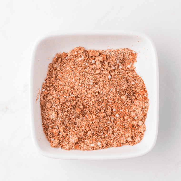 Mixing paprika, garlic powder, onion powder, chili powder, brown sugar, salt, cayenne pepper, and black pepper in a small bowl.