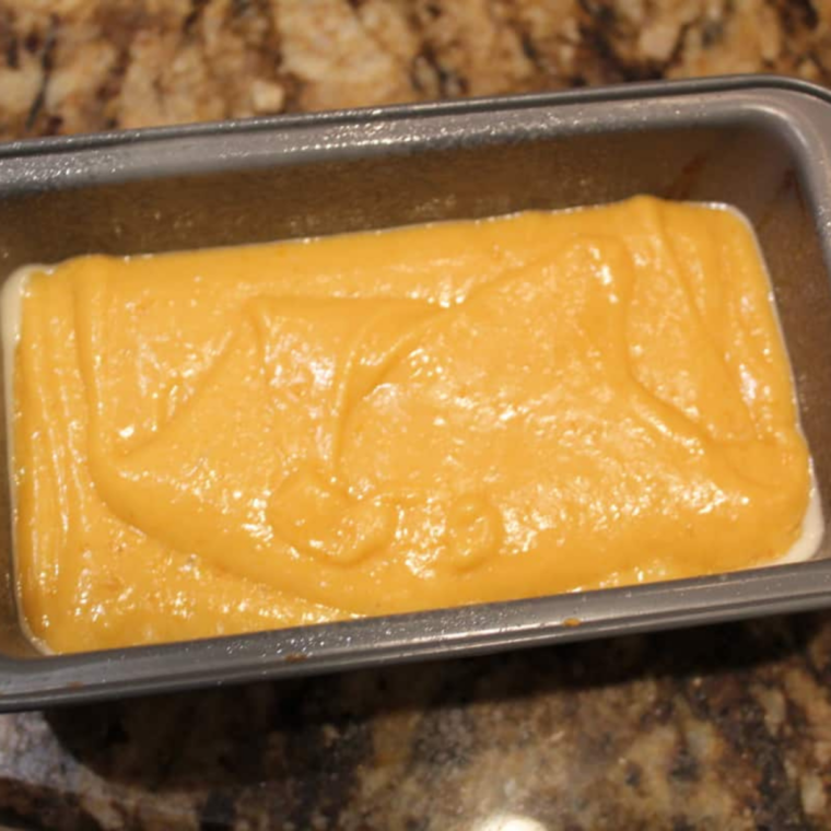 Two mini loaf pans of pumpkin bread batter placed inside an air fryer basket