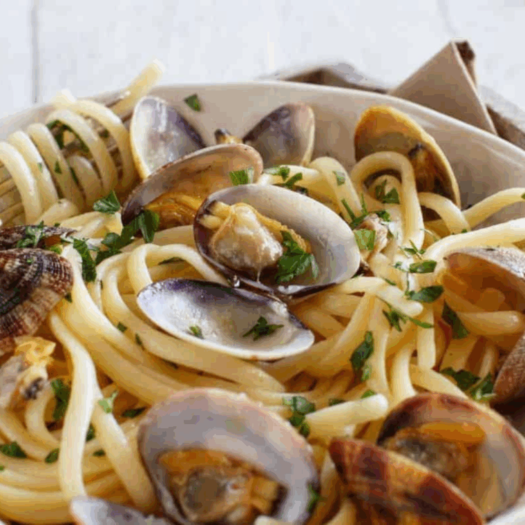 Freshly steamed clams cooked in the Instant Pot with garlic, butter, and white wine, served in a bowl.