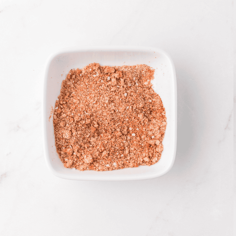 Mixing cayenne pepper, garlic powder, onion powder, and spices."