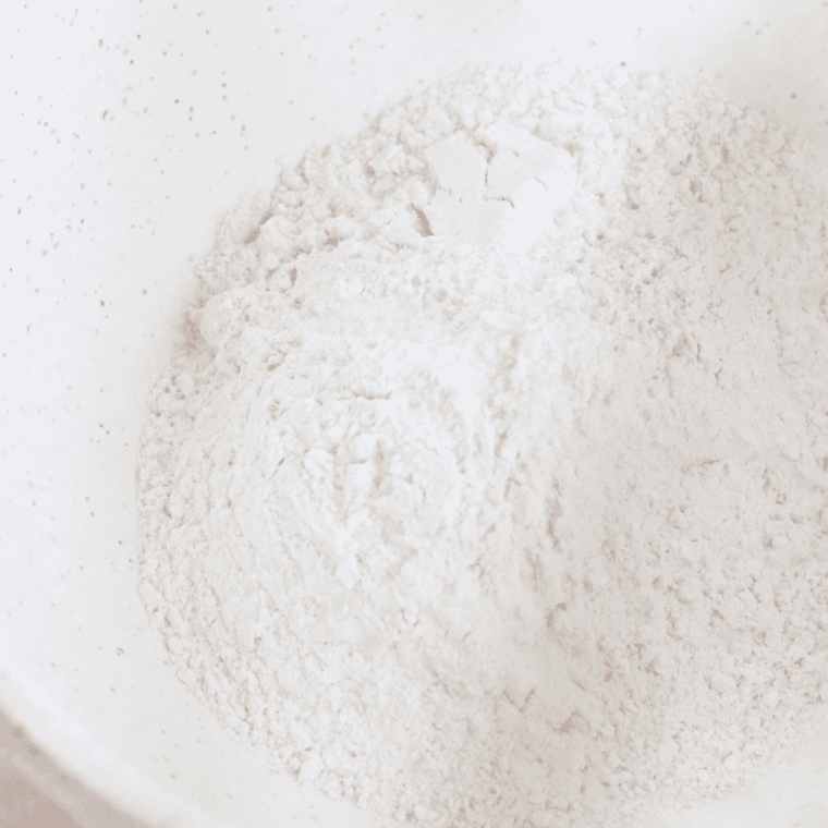 Whisking flour, baking powder, and sugar together in a large mixing bowl 
