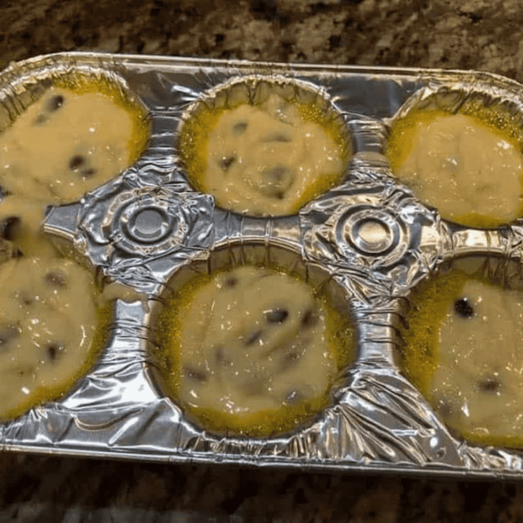 Silicone muffin cups filled two-thirds full with chocolate chip muffin batter