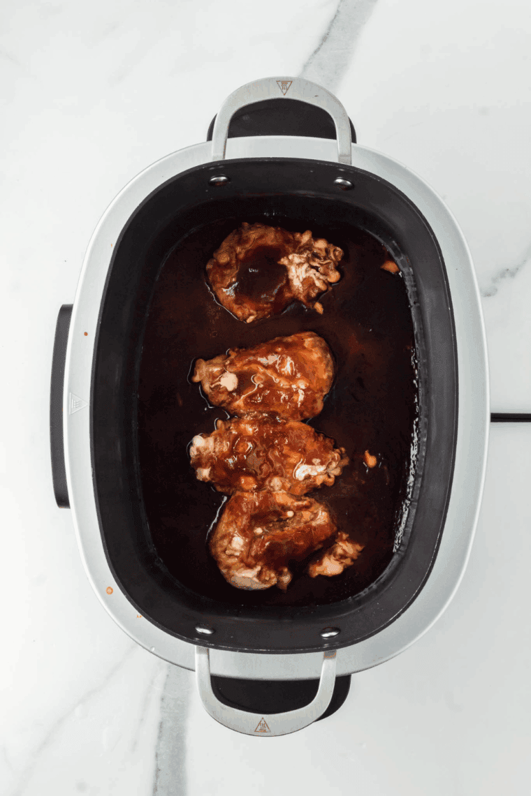 Covered slow cooker cooking BBQ chicken on low until fork-tender and ready to shred.