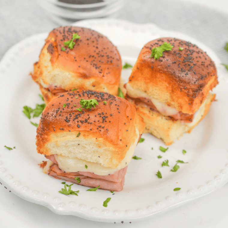 Cheesy ham and cheese sliders on King’s Hawaiian rolls cooked in the air fryer until warm, buttery, and golden brown.