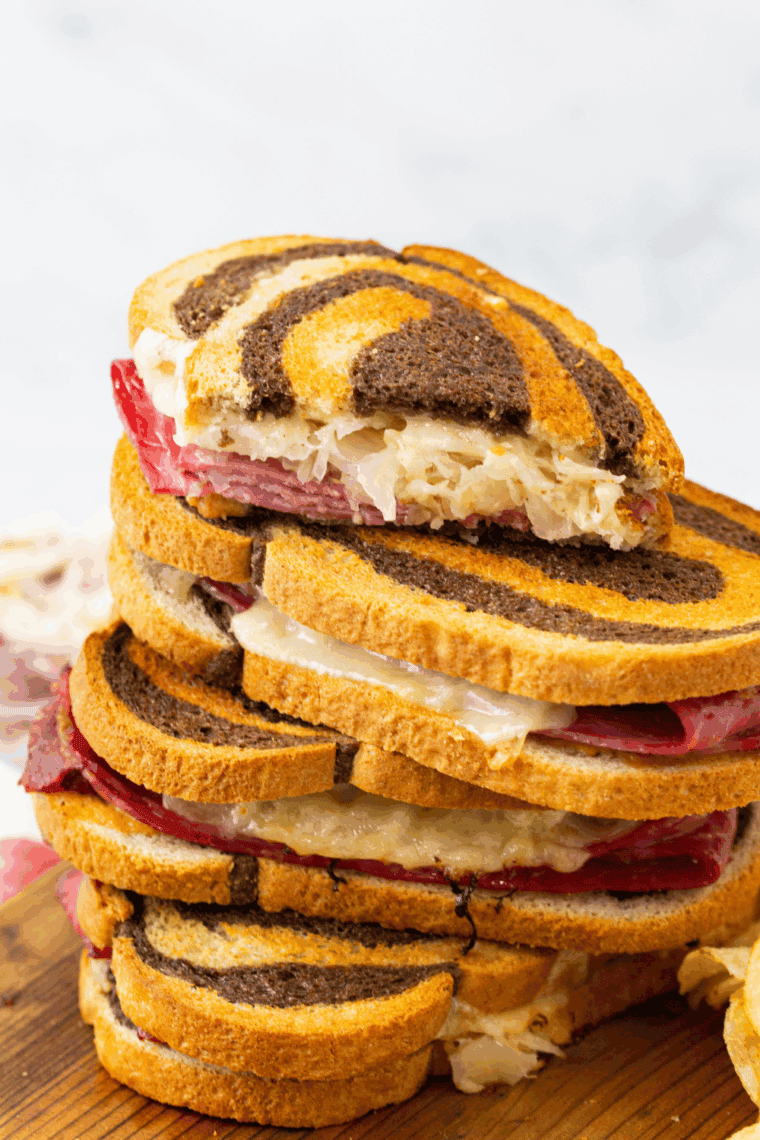 Air Fryer Reuben Sandwich with golden crispy rye bread, melted Swiss cheese, corned beef, tangy sauerkraut, and creamy Russian dressing ready to serve.