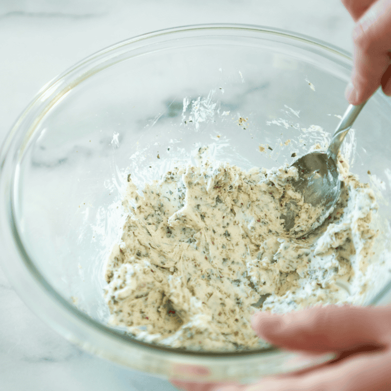 Cream cheese, breadcrumbs, parsley, onion powder and garlic powder mixed in a glass bowl