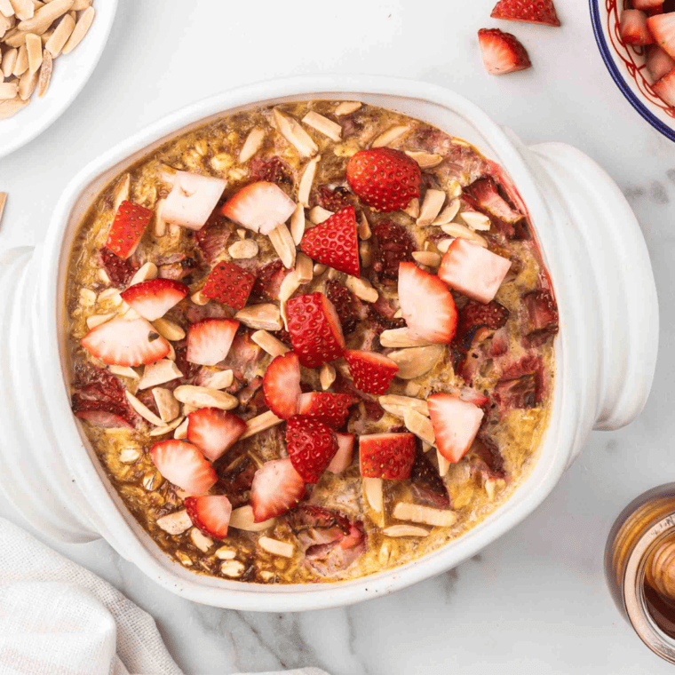 Cooked Air Fryer Strawberry Oatmeal on table with garnishes of fresh strawberries on top