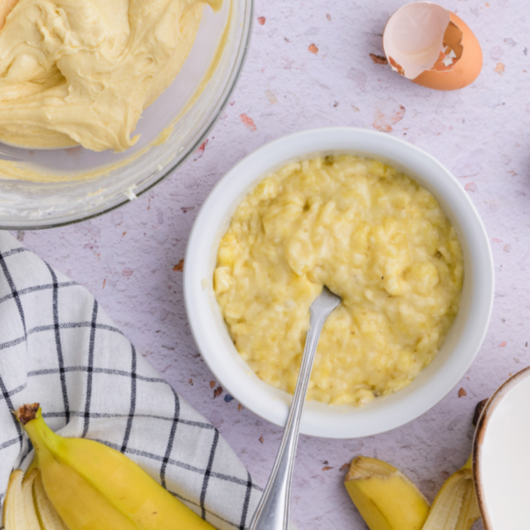 Combining mashed bananas with eggs, butter, sugars, and vanilla