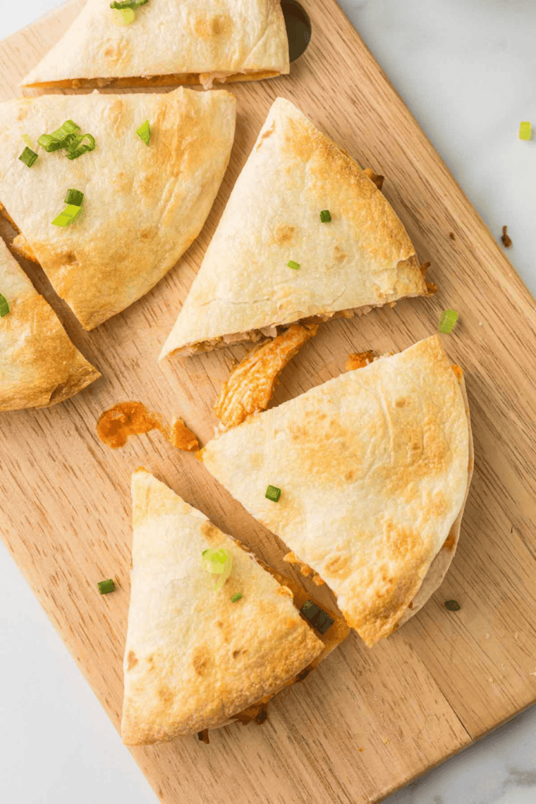 Chicken quesadilla cooking in a buttered skillet until golden brown and crispy
