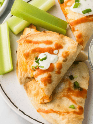 Slow cooker chicken quesadillas cut into golden wedges with melted cheese, served with guacamole and salsa