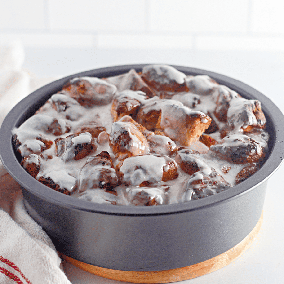 Air Fryer Cinnamon Roll French Toast drizzled with icing on a plate.