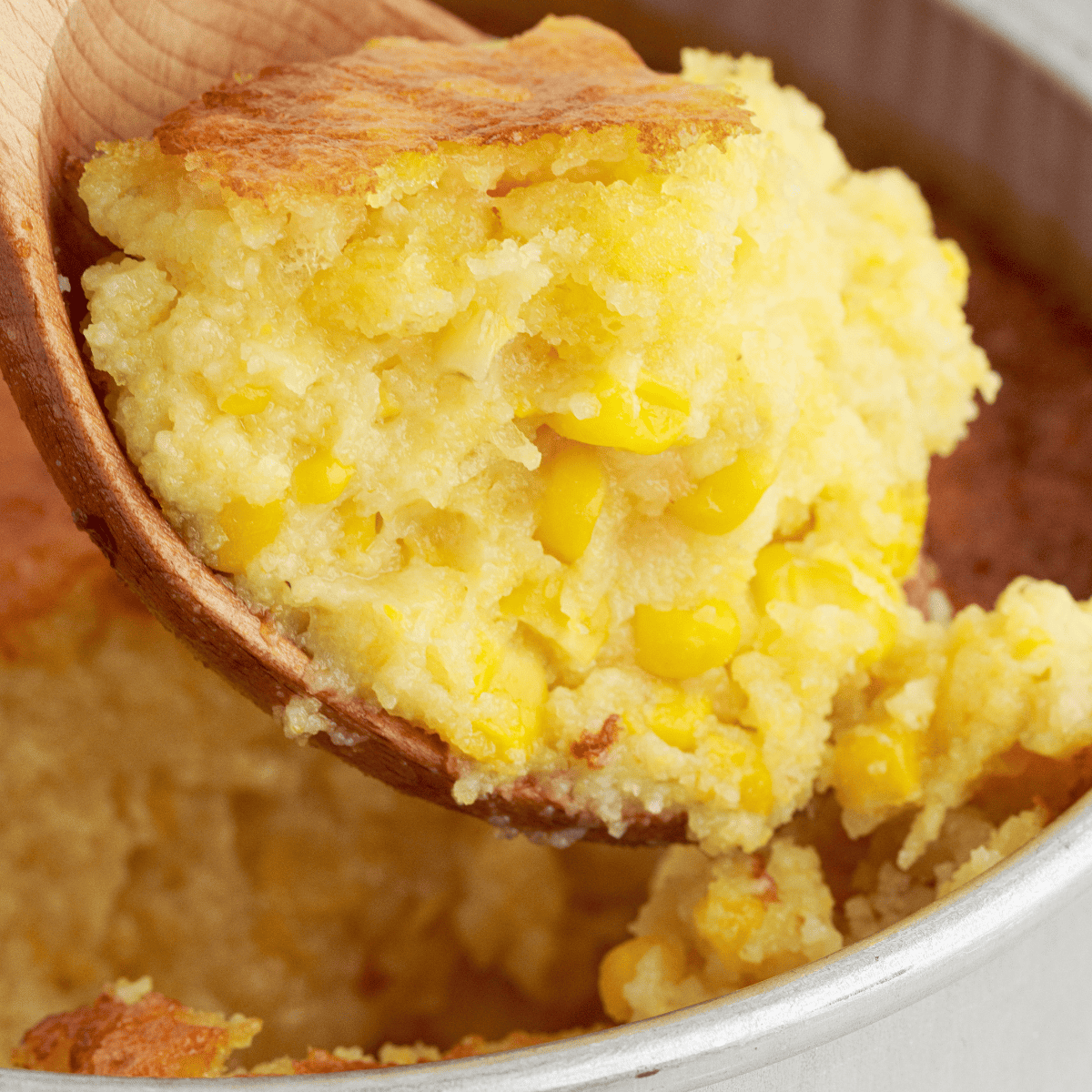 Air Fryer Jiffy Corn Casserole with a golden, crispy top and creamy center, served in a baking dish