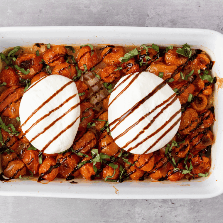 Burrata cheese nestled on roasted tomatoes with fresh basil.
