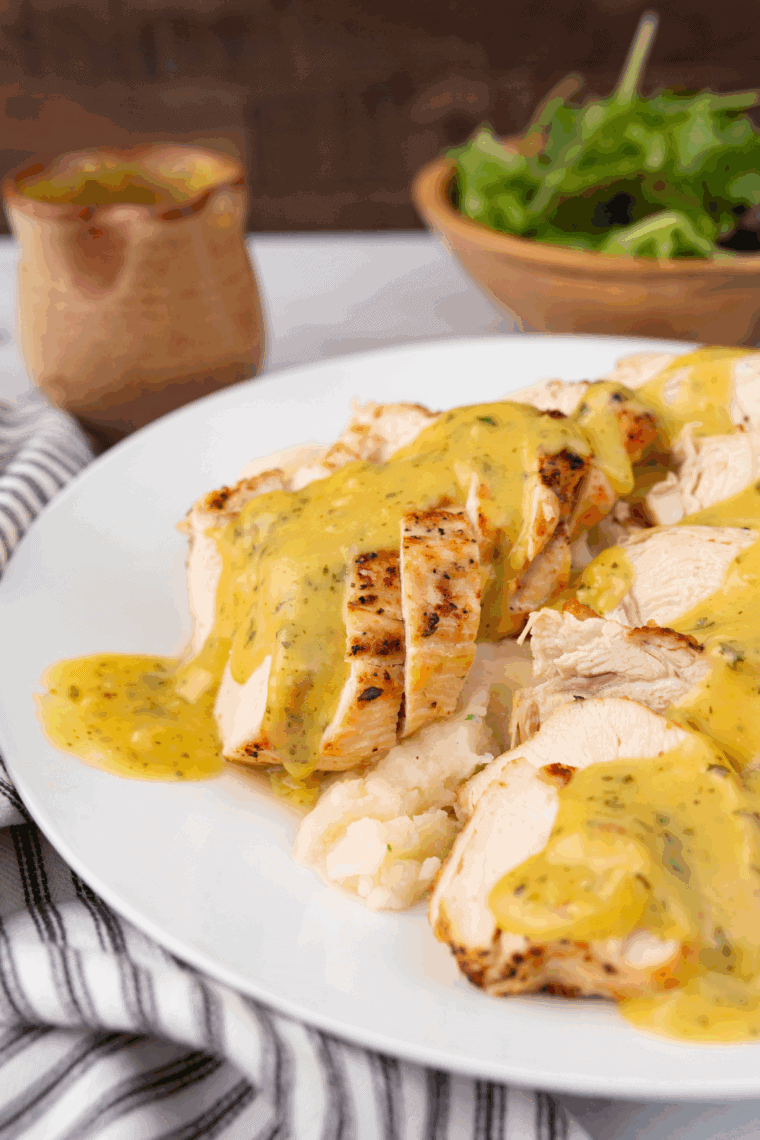 Plate of Easy Copycat Cheddar’s Dijon Chicken and Mushrooms topped with creamy Dijon sauce and sautéed mushrooms, garnished with parsley.