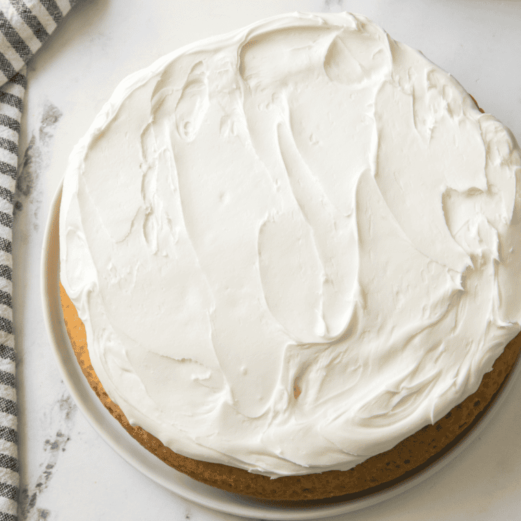 Whole Italian lemon ricotta cake on a white cake stand"