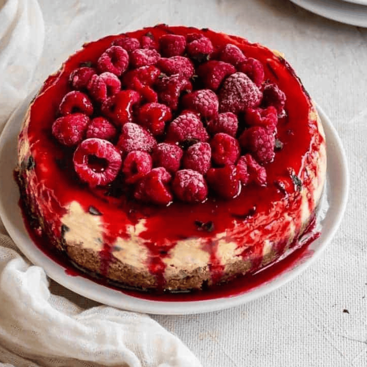 Slice of Cheesecake Factory Lemon Raspberry Cream Cheesecake with raspberry swirls and lemon topping.