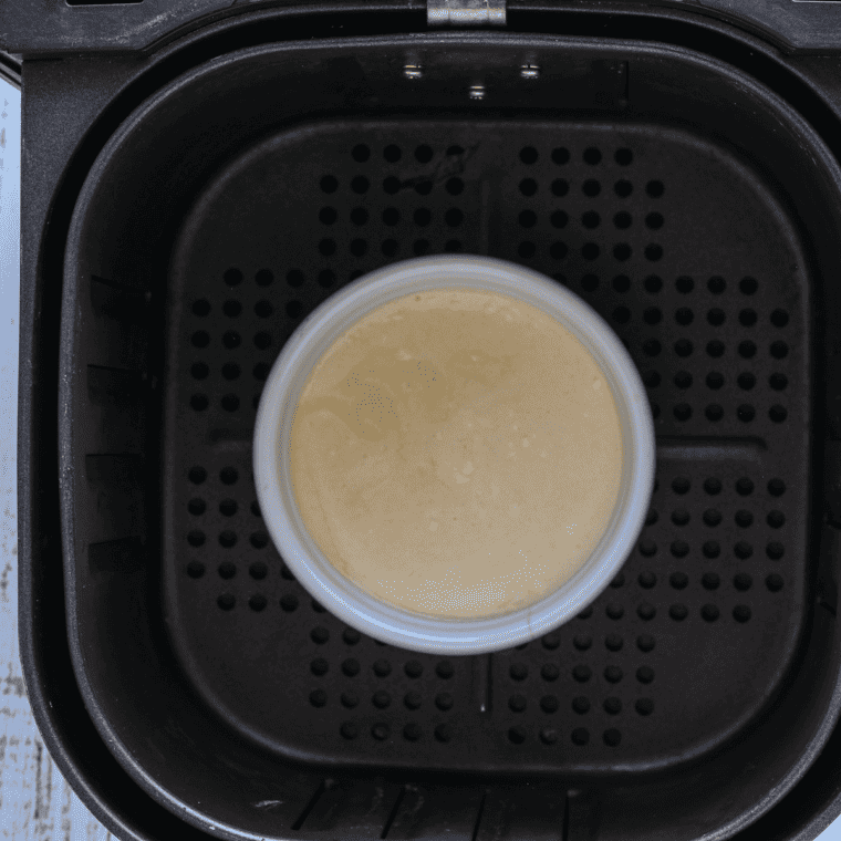 Batter for Boston cream pie being mixed in a large bowl before being poured into greased ramekins.