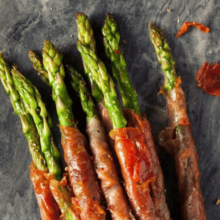 Platter of Air Fryer Prosciutto Wrapped Asparagus with crispy ham and tender green spears.