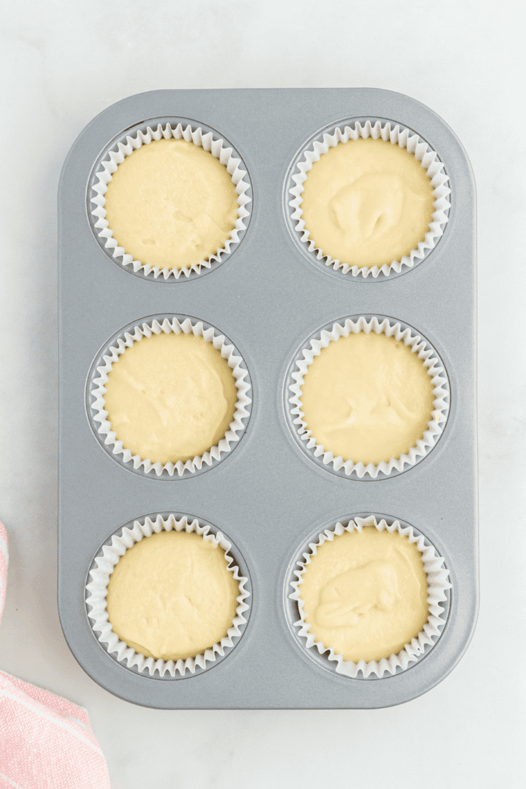 Fill the Cups – Pouring batter into cupcake liners, filling each about two-thirds full.