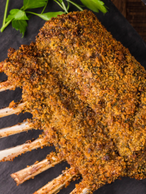 Air fryer rack of lamb with a golden garlic-herb crust, garnished with fresh rosemary on a white plate