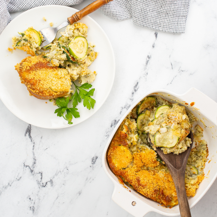 Cheesy zucchini casserole served in a white dish, ready to eat