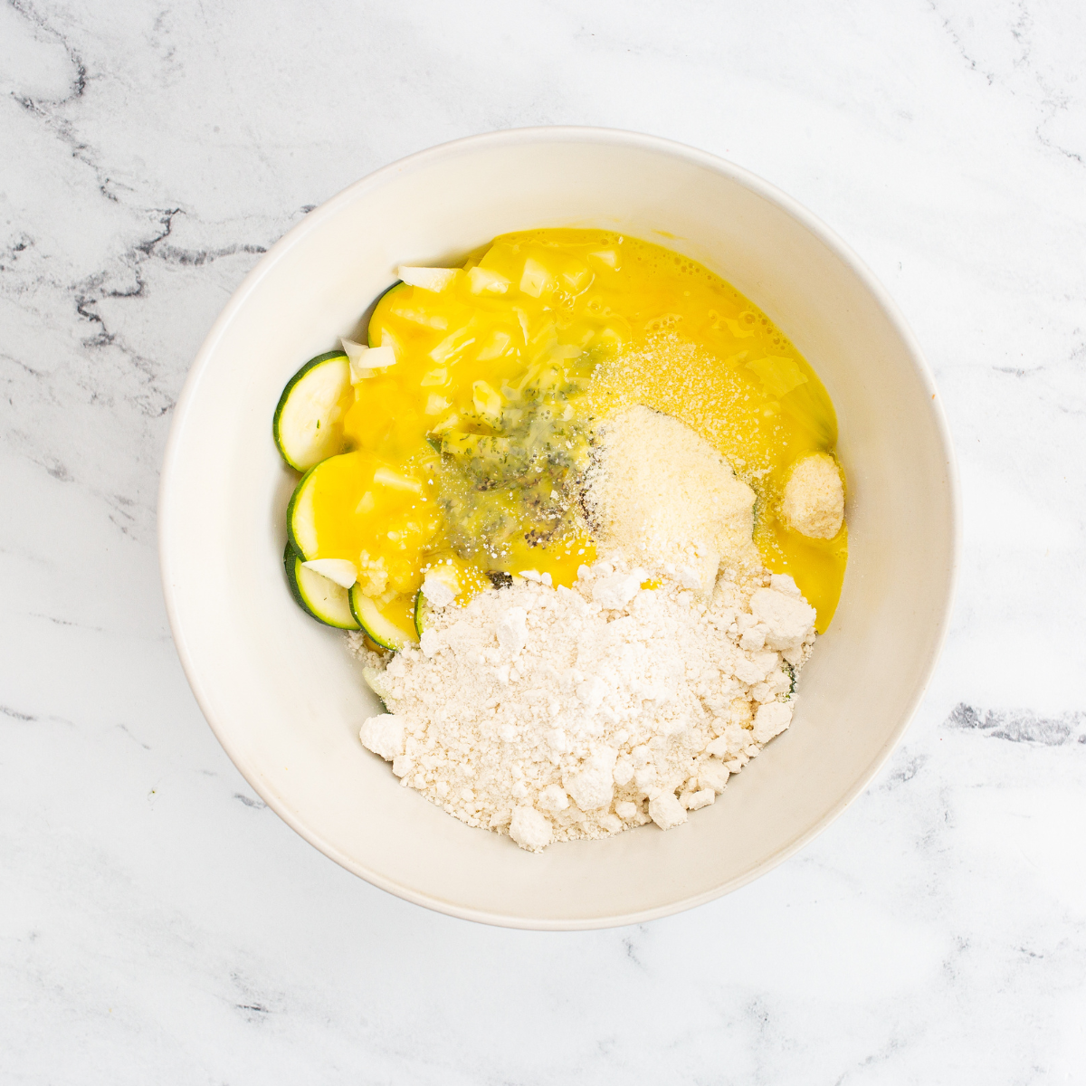 Mix spices, eggs, oil, baking mix, and cheese.