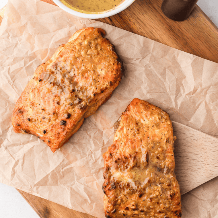 Air fryer honey mustard salmon fillet with a glossy caramelized honey-dijon glaze, garnished with parsley.