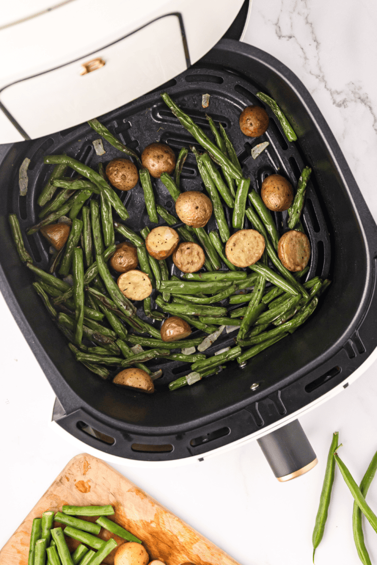 Crispy air-fried green beans and golden potatoes served on a plate, perfectly seasoned and ready to enjoy.