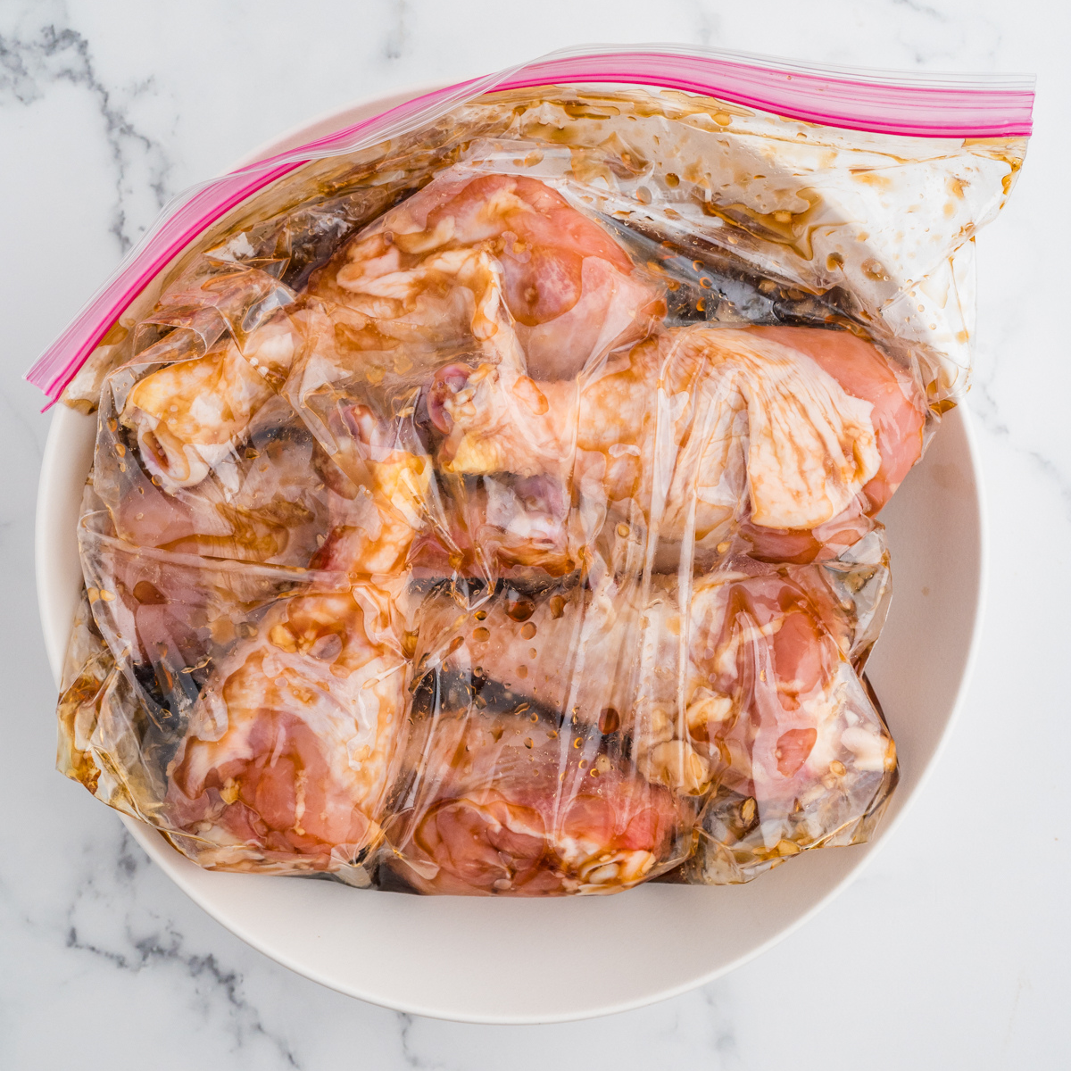 Marinated chicken drumsticks in a dish, prepared for air frying.