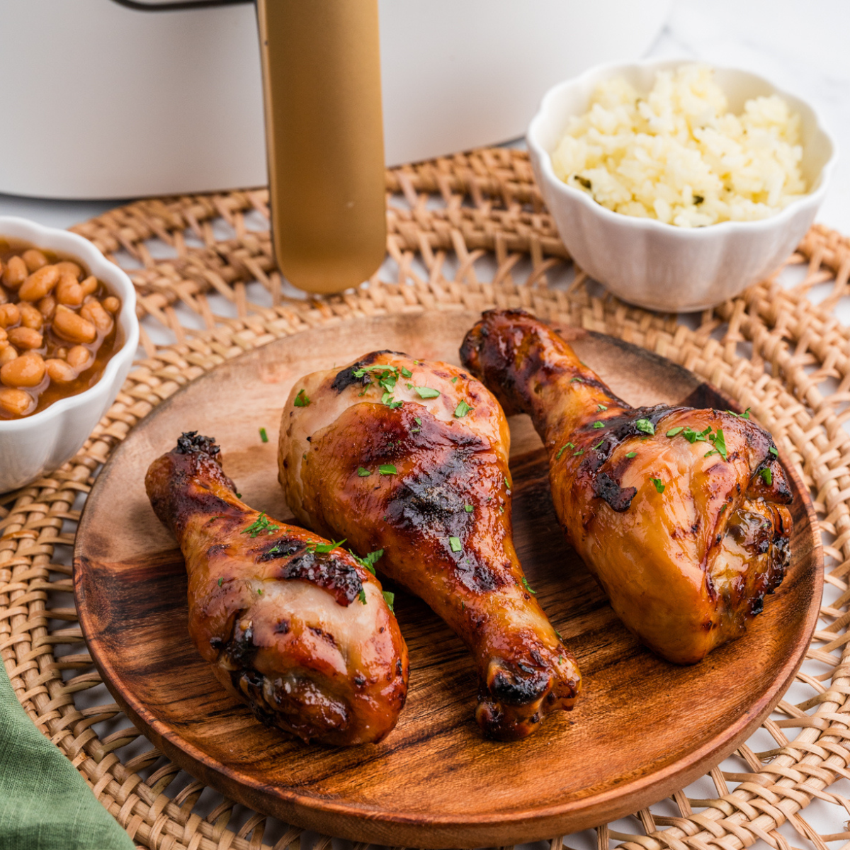 Air Fryer Honey Soy Chicken Drumsticks coated in a glossy honey soy glaze, served on a plate with garnishes.