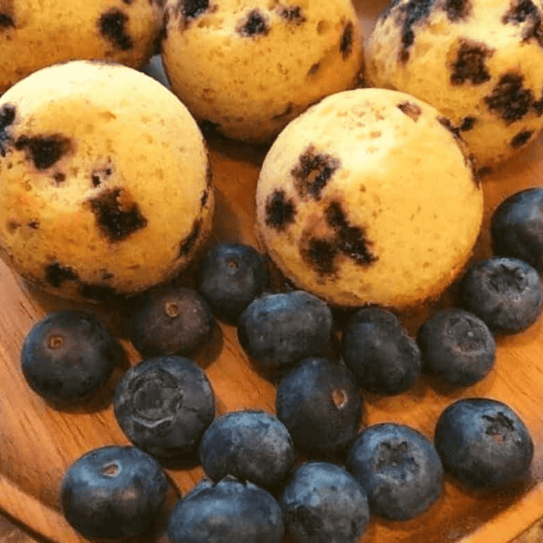 Golden, bite-sized blueberry muffins made in the air fryer with soft, fluffy centers