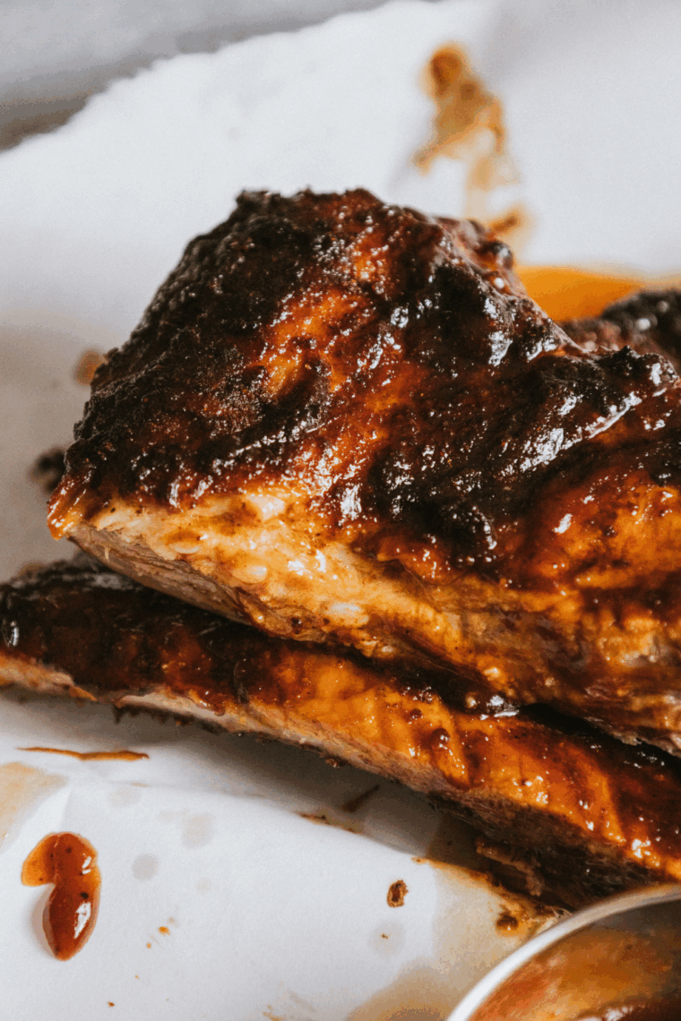 Close-up of air fryer Chili’s baby back ribs coated in BBQ sauce and served with a side of fries and coleslaw.