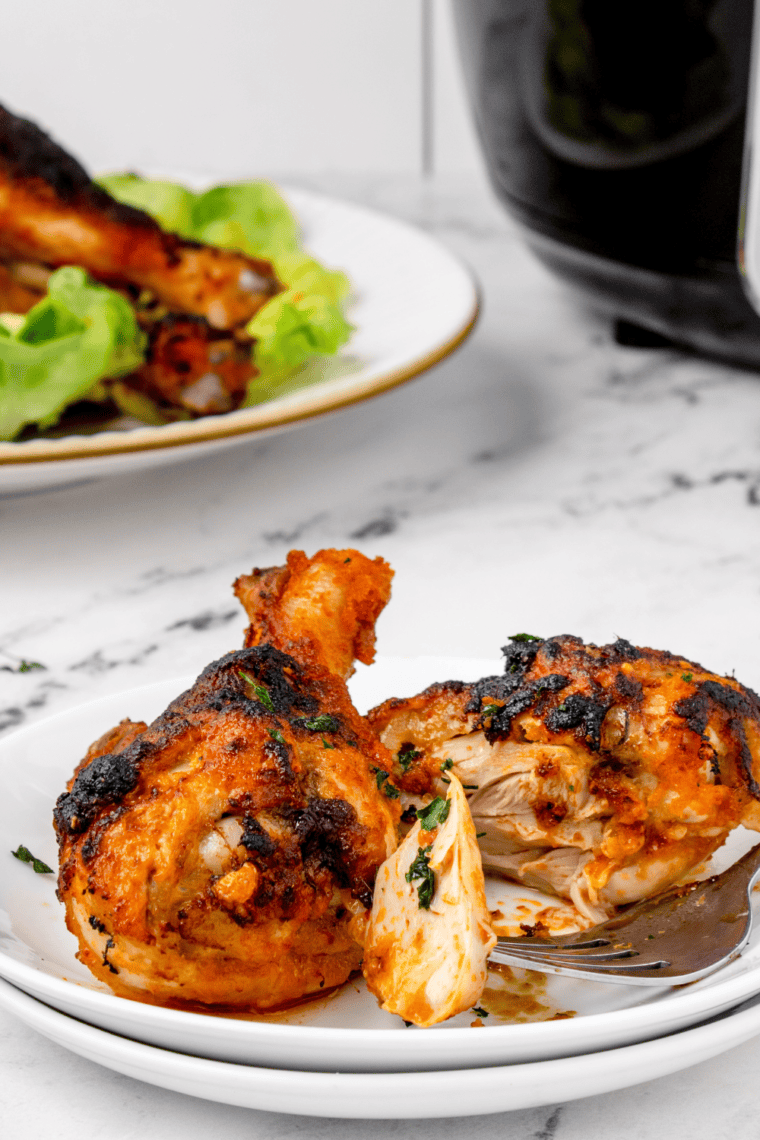 Close-up of crispy buffalo drumsticks fresh from air fryer with sauce glaze