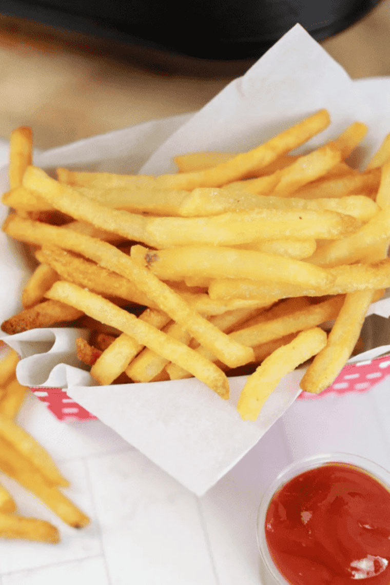 Golden, crispy Ninja Crispi frozen French fries served in a basket, perfect for a quick snack or side dish.