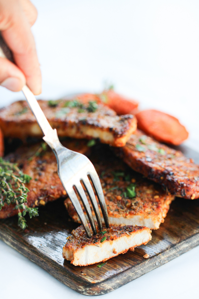 Air fryer pork steaks cooked to golden-brown perfection on a serving plate